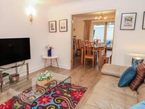a living room with a couch and a flat screen tv at 2 Carr Farm Close in Glossop