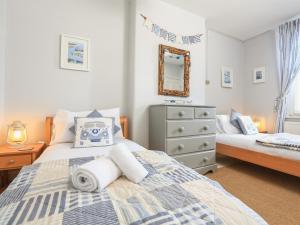 達特茅斯的住宿－Sandquay View，一间卧室配有两张床、一个梳妆台和镜子