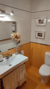 a bathroom with a sink and a toilet and a mirror at Ático con terraza en el puerto de Aguadulce in Aguadulce