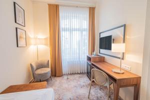 a hotel room with a desk and a television at Hotel Villa am Kurpark in Bad Homburg vor der Höhe