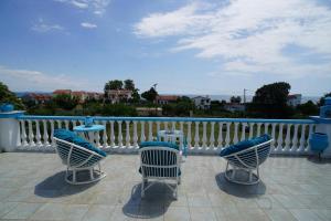 a group of chairs and tables on a balcony at Villa Stella-Maria in Paralía Avdhíron