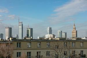 a building with a city skyline in the background at Miejski czar Retro. Plac Zbawiciela! in Warsaw