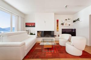 ein Wohnzimmer mit weißen Möbeln und einem Kamin in der Unterkunft Sonnenschein in Brione sopra Minusio