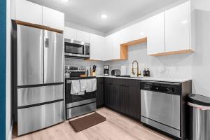 a kitchen with stainless steel appliances and white cabinets at Stylish 2 bed 1 Mile to downtown Free parking in Dallas