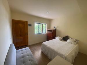 een slaapkamer met een bed en een raam bij El refugio de Jhan in Vilcabamba