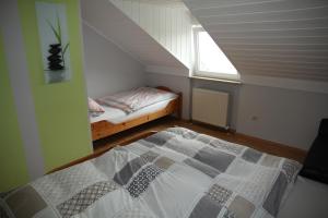 ein kleines Schlafzimmer mit einem Bett und einem Fenster in der Unterkunft Ferienwohnung Gerda in Zandt