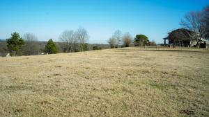 an open field with a house in the background at Nordins Hillside Meadow View Cabin in Coffeyville
