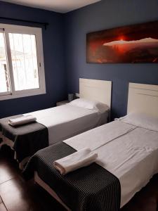 Duas camas num quarto com paredes azuis em Villa Cambrils Mar em Cambrils