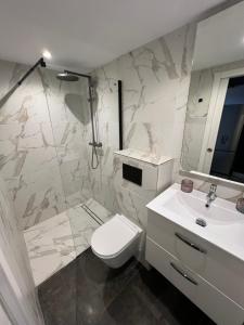 uma casa de banho com um WC, um lavatório e um chuveiro em Mini duplex moderno bien ubicado. em Tarifa