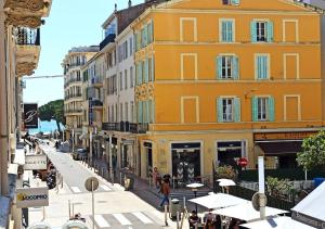 une rue avec des bâtiments et des personnes marchant dans une rue dans l'établissement Viva Riviera Residence Marina Croisette, à Cannes