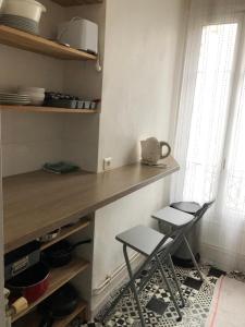 uma cozinha com dois bancos e um balcão num quarto em Appartement charonne em Paris