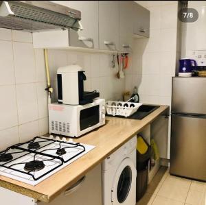 Il comprend une cuisine équipée d'une cuisinière et d'un four micro-ondes. dans l'établissement Appartement charonne, à Paris