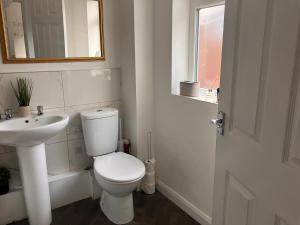 a white bathroom with a toilet and a sink at Stadium Cottage - Close to Centre, Stadium, Nissan and CrownWorks Studios in Sunderland +22 photos