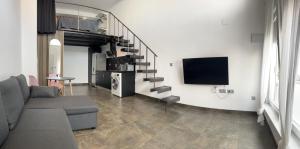Una sala de estar con un sofá y un televisor. en Mini duplex moderno bien ubicado., en Tarifa