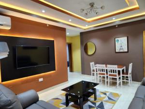 a living room with a couch and a tv and a table at The Morville Suites and Apartments in Abeokuta