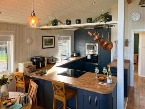cocina con armarios azules y encimera de madera en Green Vale Lodge, Yanwath, Ullswater, en Tirril