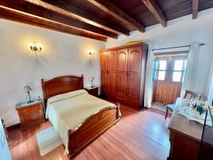 Schlafzimmer mit einem Bett und einem Holzschrank in der Unterkunft Guanche 'Casa rural canaria' in San Miguel de Abona