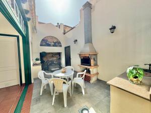 a patio with a table and chairs and a fireplace at Guanche 'Casa rural canaria' in San Miguel de Abona