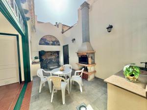 Un patio con mesa y sillas y una chimenea. en Guanche 'Traditional Canarian House', en San Miguel de Abona