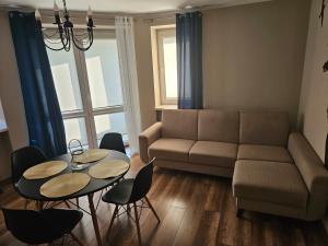 a living room with a couch and a table and chairs at Apartament blisko jeziora in Ełk