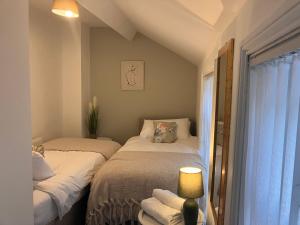 1 dormitorio con 2 camas, lámpara y ventana en Sunderland Stays - Stadium of Light, City Central, HS WiFi, Secure Free parking, Smart TV en Monkwearmouth