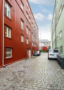 un bâtiment rouge avec des voitures garées devant lui dans l'établissement Fjord view by the canal - apartment, à Trondheim