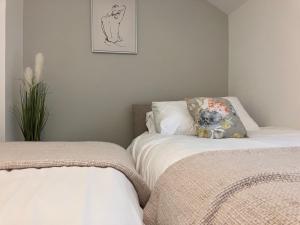 two beds sitting next to each other in a bedroom at Stadium Cottage - Close to Centre, Stadium, Nissan and CrownWorks Studios in Sunderland