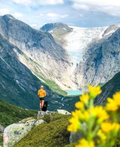 a person standing on top of a mountain overlooking a valley at Flo Bellevue in Stryn