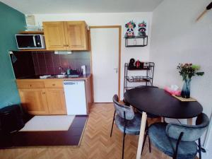 een keuken met een tafel en stoelen in een kamer bij Appartement ski in out 5 in Les Houches