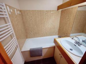 een badkamer met een wastafel en een bad bij Appartement ski in out 5 in Les Houches
