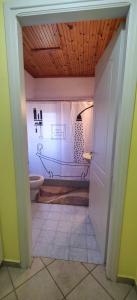 een badkamer met een toilet met een tekening op de muur bij Peak heaven in Feneos