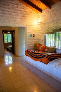een slaapkamer met een groot bed in een stenen muur bij Casa de Campo en Oceanía in Rincón de los Oliveras