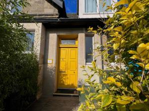 una puerta amarilla en el lateral de un edificio en Leith House, en Edimburgo