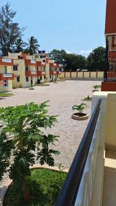 an empty courtyard with palm trees and buildings at Noni's Place, Greenwood Gardens, Mtwapa in Mtwapa
