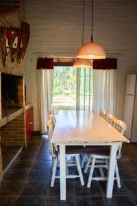 a dining room with a wooden table and chairs at Casa de Campo en Oceanía in Rincón de los Oliveras