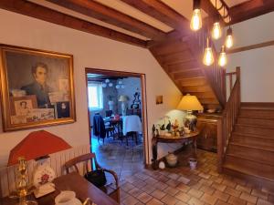 a living room with a staircase and a dining room at Domaine Bassy in Saint-Gengoux-de-Scissé
