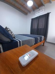 a remote control sitting on a table next to a couch at Sueños Del Pilar II in Godoy Cruz