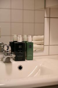 un lavabo con dos botellas de jabón. en Hotel feeling in the center of Trondheim, en Trondheim
