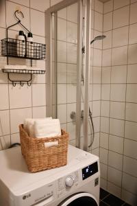 a washing machine with a basket on top of it in a bathroom at Hotel feeling in the center of Trondheim in Trondheim