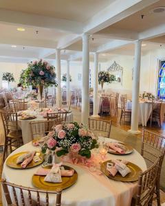 un salón de banquetes con mesas con flores. en The Grenville Hotel and Restaurant en Bay Head