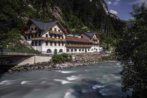 a building next to a river next to a mountain at Hostel Chillertal in Mayrhofen