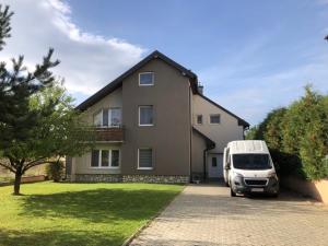 un furgone bianco parcheggiato di fronte a una casa. di Relax Villa Tatry - Wifi/TV, BBQ, Billiard a Nová Lesná