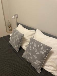 two pillows sitting on top of a bed at Cozy, bright apartment. Swimming pool, parking, gym, PREMIUM in Warsaw