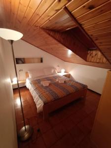 um quarto com uma cama e um candeeiro de chão em [Aprica 4 min. piste baradello] em Aprica