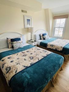 a bedroom with two beds with blue comforters at The Grenville Hotel and Restaurant in Bay Head
