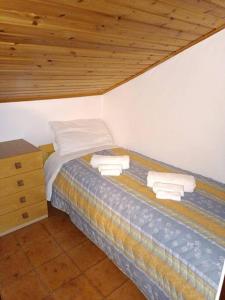 uma cama num quarto com tecto em madeira em [Aprica 4 min. piste baradello] em Aprica