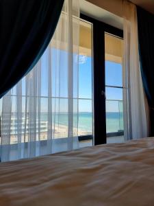 - une chambre avec un lit et une vue sur la plage dans l'établissement Studio Horizon - Endless Summer Mamaia Nord Apartaments, à Mamaia Nord – Năvodari