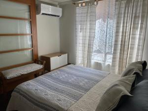 um quarto com uma cama em frente a uma janela em Departamento en el corazón de Providencia em Santiago
