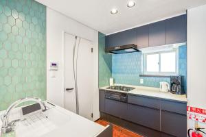 cocina con azulejos azules y blancos y fregadero en Best Location LUX Home, 2 Blocks to Sbwy, Sleeps 9, en Sapporo