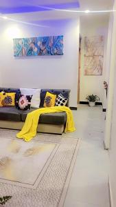 a living room with a couch with a yellow blanket at F&;D villas in Dar es Salaam